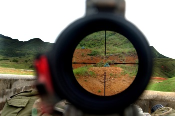 040521-M-1012W-014 Camp Hansen, Okinawa, Japan (May 21, 2004) - A Special Reaction Team (SRT) member looks through the scope of a sniper rifle to help enlarge targets. Training targets are often hundreds of meters away and using the sniper rifle scope ensures the sniper has a clear shot at his intended target. U.S. Marine Corps photo by Cpl. Ryan Walker (RELEASED)